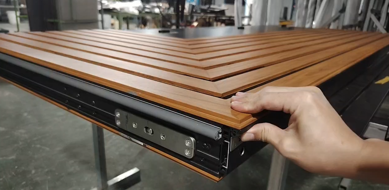 Automatic bottom seal on a COSYHOUSE pivot door, descending to create an airtight seal when closed for enhanced insulation and soundproofing